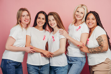Women embracing and showing pink ribbons for breast cancer awareness