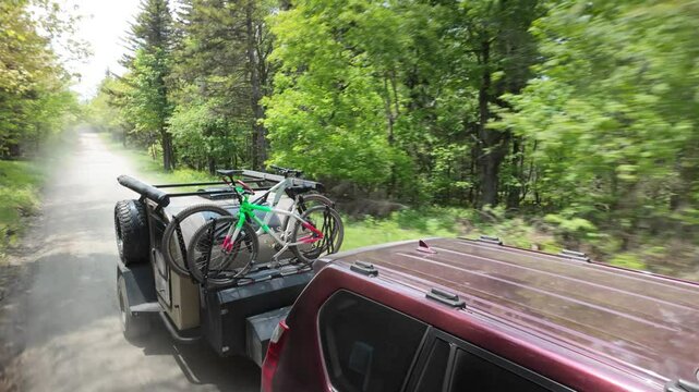 A family enjoys a camping trip in the Appalachian Mountains, towing a teardrop trailer and bicycles through the lush greenery of Dolly Sods.