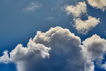 The top of a cumulus cloud under sunlight in a blue sky during the day, close-up, the top of the...