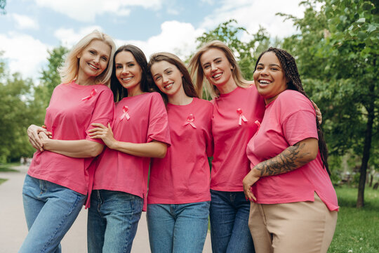 Smiling women wearing pink supporting breast cancer awareness in park