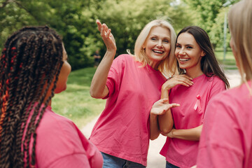 Volunteers wearing pink ribbon on shirts supporting breast cancer awareness campaign in park
