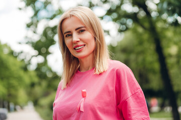 Woman wearing pink ribbon showing support for breast cancer awareness month