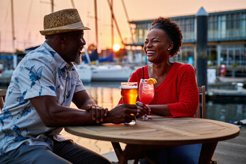 Elderly couple enjoying a drink at seaside restaurant during vacation