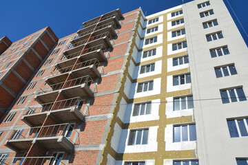 Apartment building during construction made of brick, as well as external thermal insulation with...