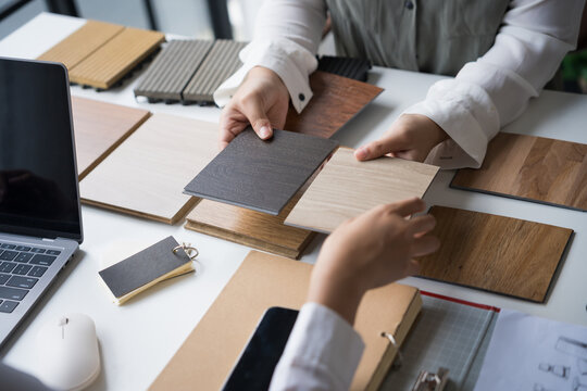 Interior designer presenting eco friendly wooden material samples for sustainable home decor