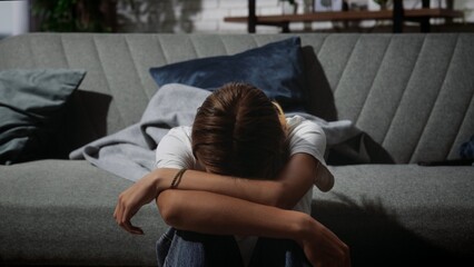 Young Woman Sitting on Sofa Feeling Overwhelmed by Emotions