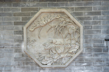 Stone carving on brick wall with floral design