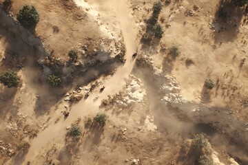 Obraz premium High-angle view of a dusty path winding through a dry, rocky landscape.