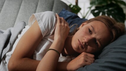 Concerned Young Woman Relaxing On Comfortable Sofa