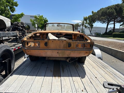 Fototapeta The rear view of a classic, old Triumph Spitfire sports car, loaded on a trailer in San Marcos, California, showcasing its iconic tail lights and design.