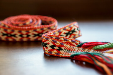 Traditional Lithuanian woven national band with colorful ethnic patterns, displayed on a wooden...