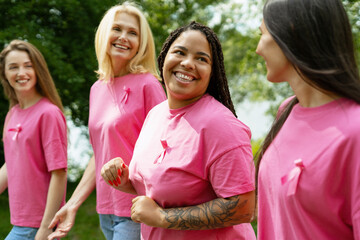 Diverse women walking together for breast cancer awareness, showing pink ribbons