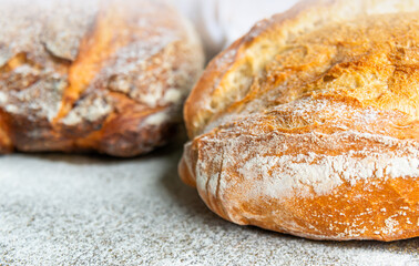 Freshly baked artisan bread loaves on a rustic countertop with flour dusting in a cozy kitchen