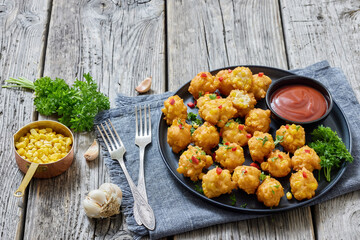 corn nuggets on a plate with tomato sauce