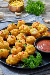 corn nuggets on a plate with tomato sauce