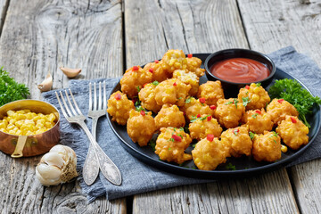 corn nuggets on a plate with tomato sauce