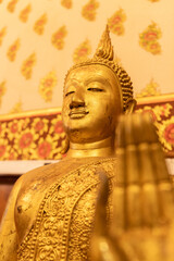 Golden Buddha statue in a temple in Ayutthaya, Thailand. 