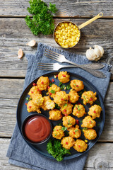 corn nuggets on a plate with tomato sauce