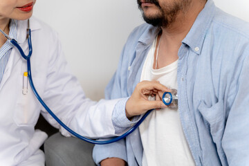 Physician listening to patient’s breath sounds with stethoscope during routine health checkup.