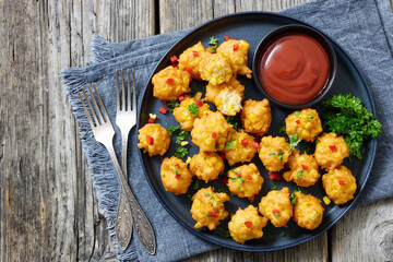 corn nuggets on a plate with tomato sauce