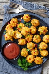 corn nuggets on a plate with tomato sauce