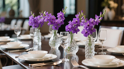 A beautifully set dining table with pristine white tableware, clear wine glasses, and polished silverware—brought to life by multiple vases of vivid purple flowers