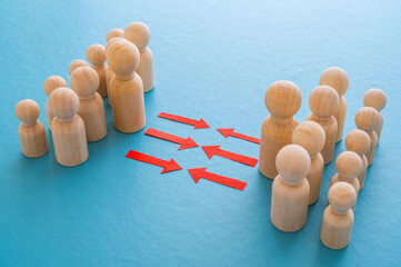 Concept of conflict I war between people or groups. Wooden figures gathered in two groups facing each other.