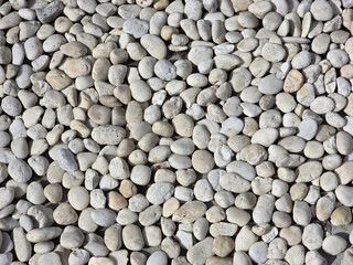 Smooth, rounded pebbles in various shades of gray and white create natural, textured surface, perfect for landscaping or decorative purposes