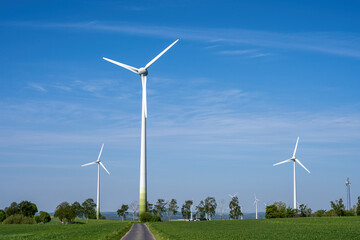 Modern wind turbines with a small country road seen in Germany
