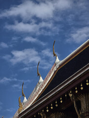 Majestic temple roof with intricate details against bright blue sky, showcasing traditional architecture and decorative elements