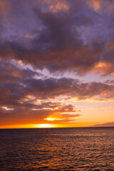 Naklejka premium Beautiful sunset or sunrise in the island of Hawaii by the ocean with a sail boat on the distance