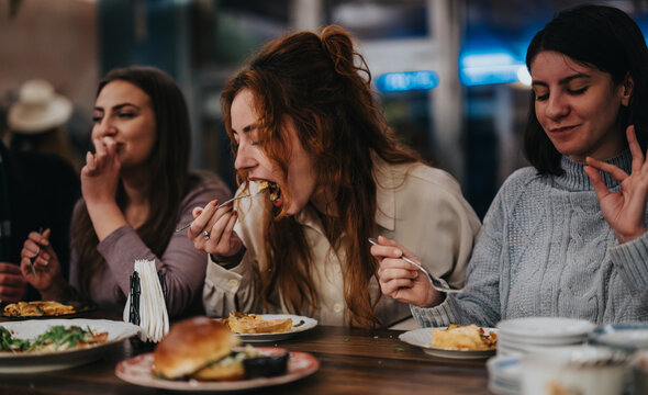 A lively scene depicting friends sharing a meal at a restaurant, showcasing togetherness, good food, and joyful moments. The atmosphere reflects leisure and social engagement among the group.
