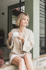 stylish girl, blonde holding cup of coffee, warming drink, good start of day, coffee aroma