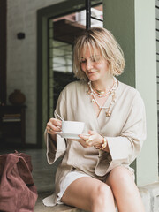 stylish girl, blonde holding cup of coffee, warming drink, good start of day, coffee aroma