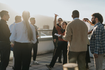 A group of multiracial, business colleagues gather on a rooftop terrace to celebrate success with...
