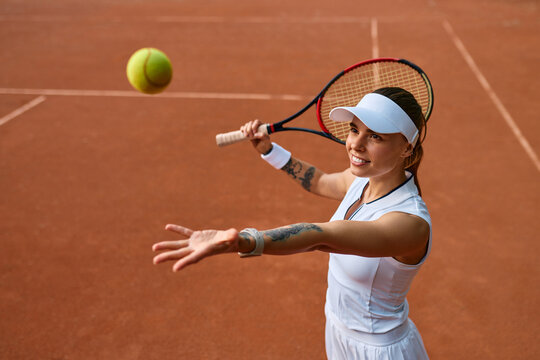 Female tennis player tossing ball before serve