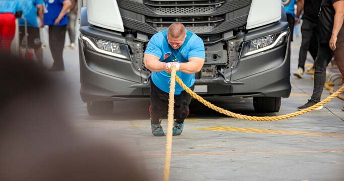 Strongman competition, strain to pull semi truck with large towrope