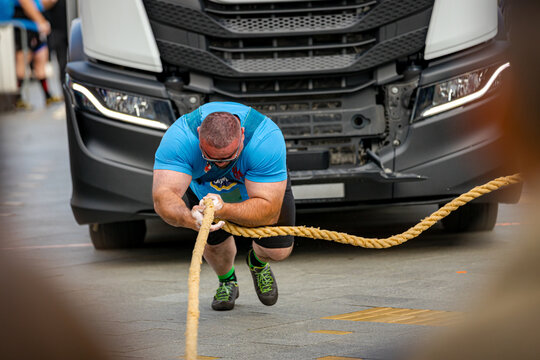 Strongman competition, strain to pull semi truck with large towrope
