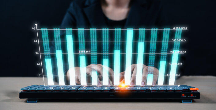 A person types on a keyboard with a digital overlay of rising bar graphs, symbolizing data analysis or financial growth.