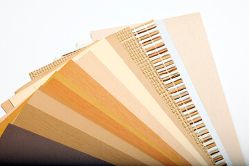 A collection of paint swatches in various shades of beige, cream, and light brown arranged in a fan...