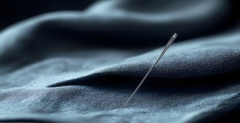 A needle is sticking out of a piece of fabric