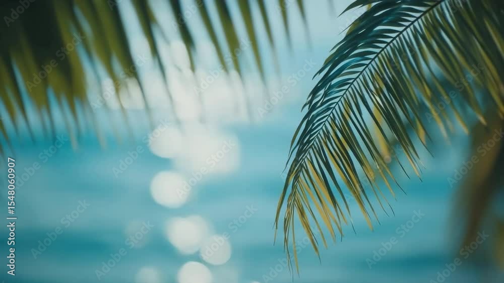 Poster palm leaves in the foreground and the sparkling sea with the sun's reflection in the background. per