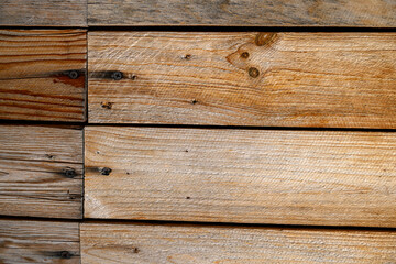 Wooden planks are neatly arranged horizontally, showcasing their natural grain and variety of brown tones.Visible knots and grain patterns add character and rustic charm to the surface,for copy space.