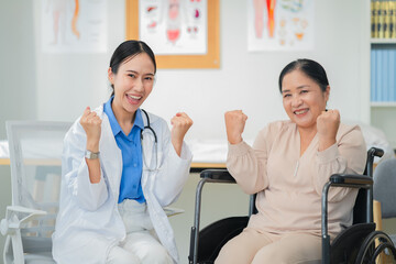Asian female doctor giving a cheerful high five to an elderly woman patient, both smiling warmly in a medical clinic setting. A joyful moment of healthcare connection, trust, and support between careg