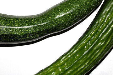 Close up of home grown cucumber courgette zucchini baby marrow vegetable skin  green on white background