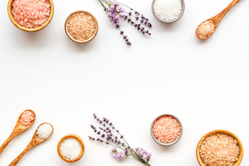 Obraz na płótnie Canvas Beauty spa therapy cosmetics and wellness flat lay - sea salt in many bowls with flowers, top view