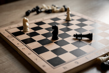 White and black chess pieces on chessboard during the game, close up