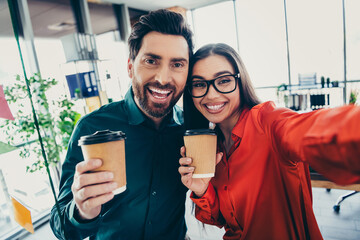 Fototapeta na wymiar Two colleagues enjoying coffee together in a modern office setting, showcasing teamwork, collaboration