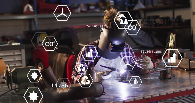 Welding woman wearing helmet holding torch generating sparks at workbench, with floating CO2 icons - Powered by Adobe