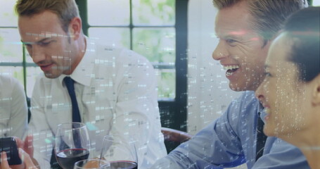 Laughing business colleagues reviewing overlay in conference room holding smartphone, wine glasses